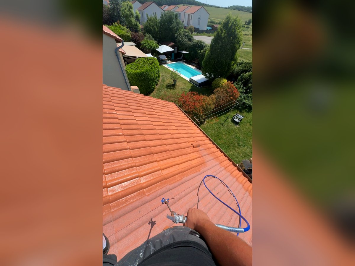 Application d'un hydrofuge coloré rouge sienne sur une toiture en Moselle par Calmel Couverture